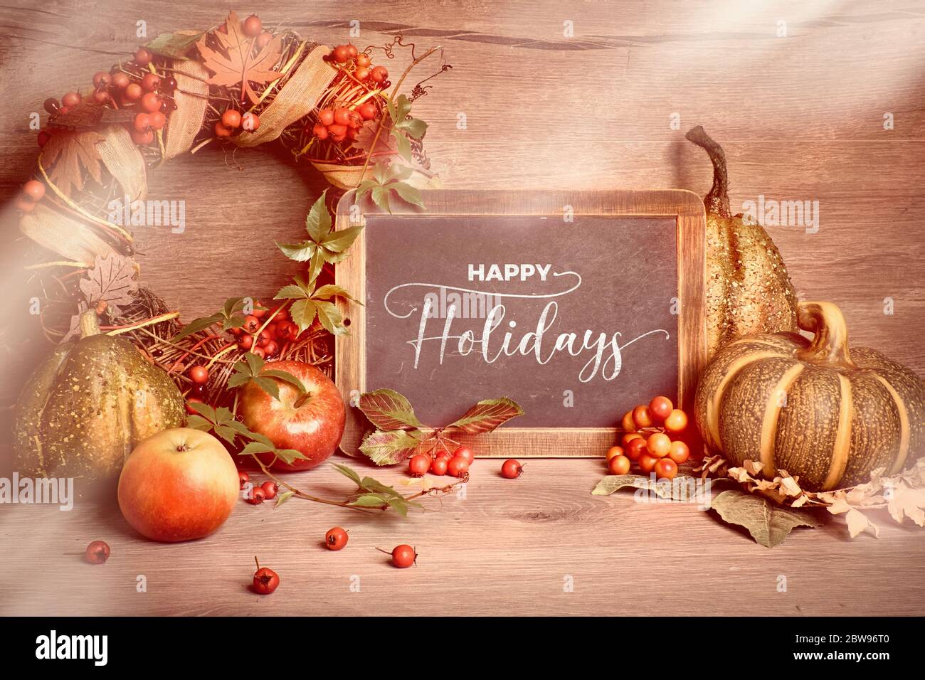 Autumn rustic decorations with text "Happy Holidays" on a chalk board
