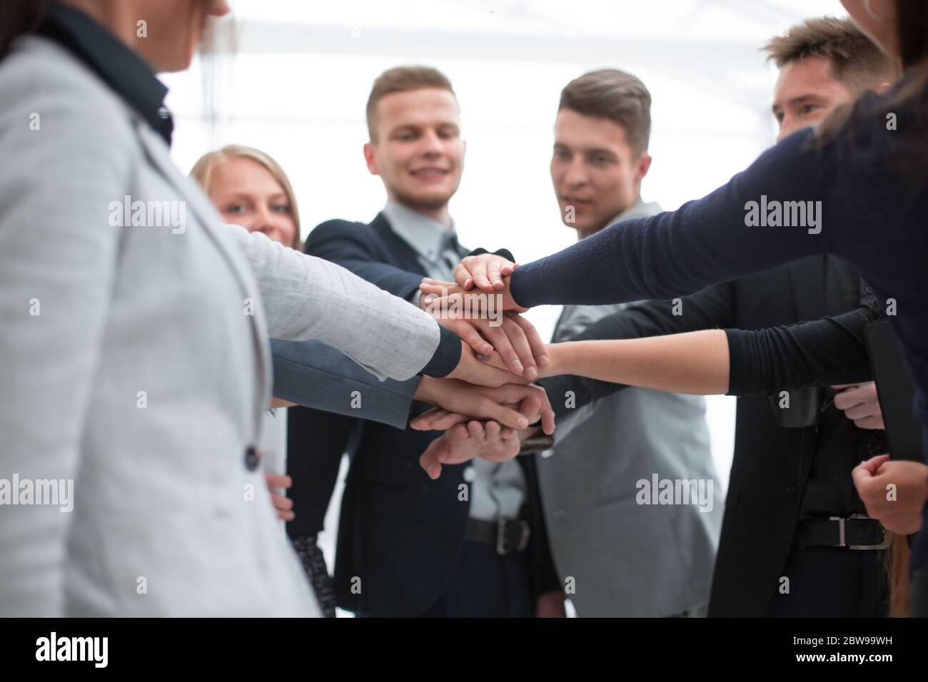 young employees making a stack out of their hands Stock Photo