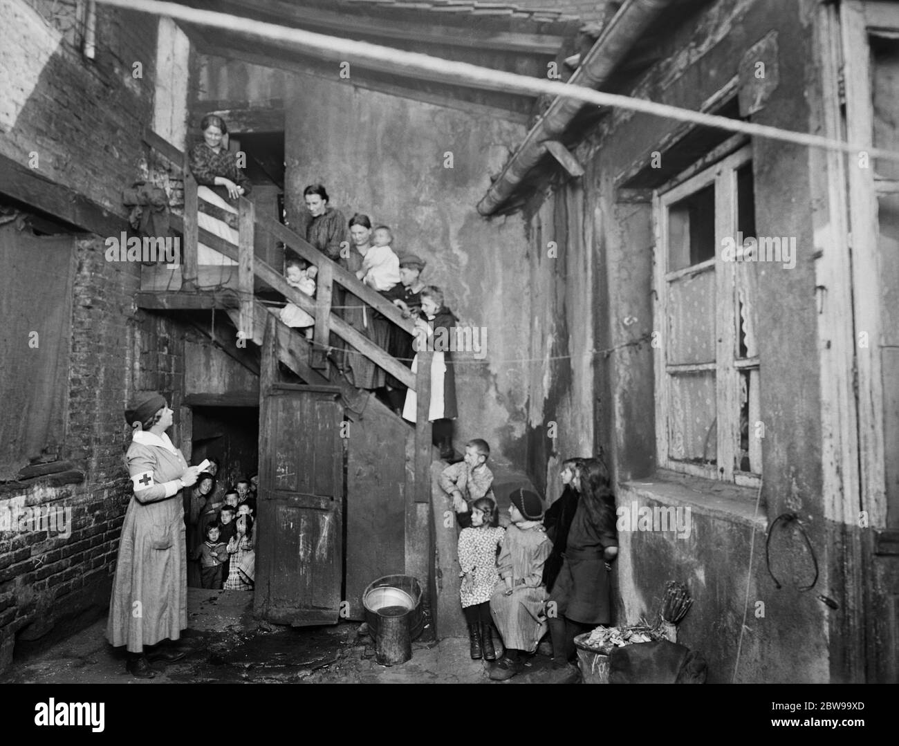 American Red Cross Nurse visiting Refugees in Housing Condemned before the War, but now being used to handle flood of Refugees coming to town, St. Etienne, France, Lewis Wickes Hine, American National Red Cross Photograph Collection, July 1918 Stock Photo