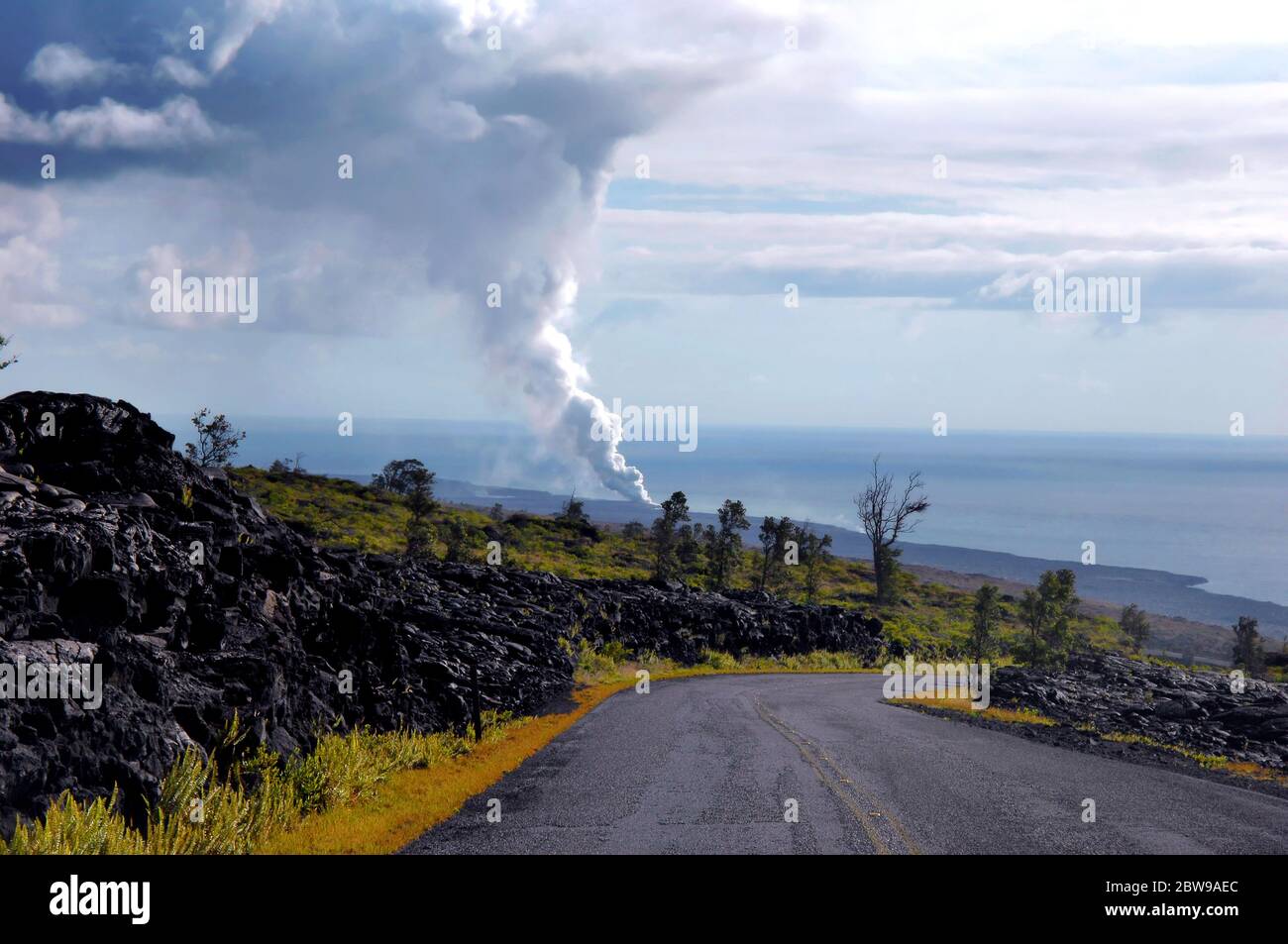 Smoke and vog billows out of the Kilauea vent as it empties into the ocean at Hawaii Volcanoes National Park on the Big Island. Stock Photo