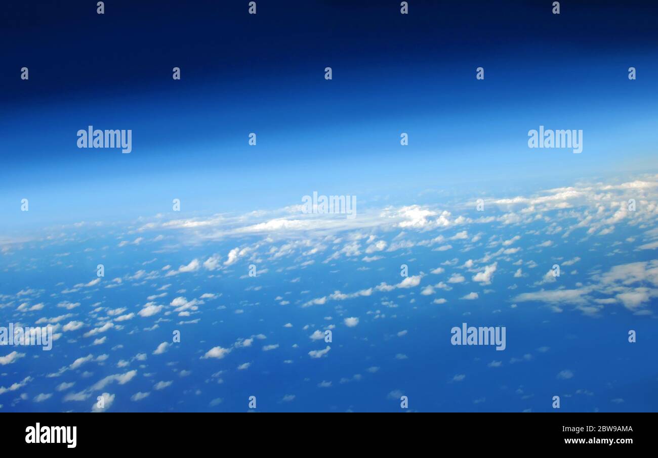 Early sunlight lights small fluffy clouds on flight over the ocean to ...