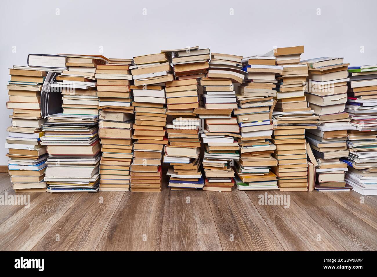 Wall of books piled up Stock Photo - Alamy