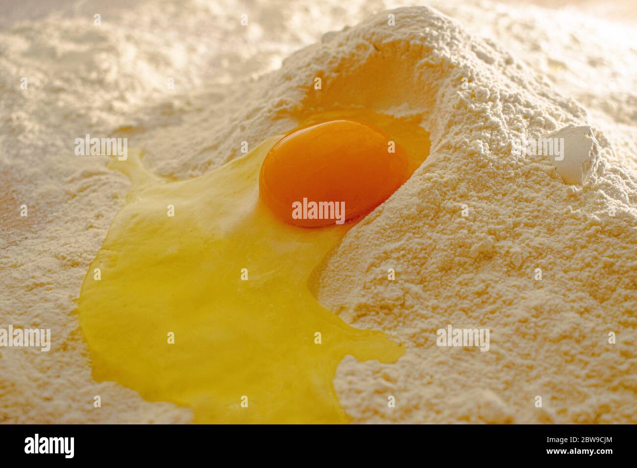Broken egg in flour, on wood table Stock Photo