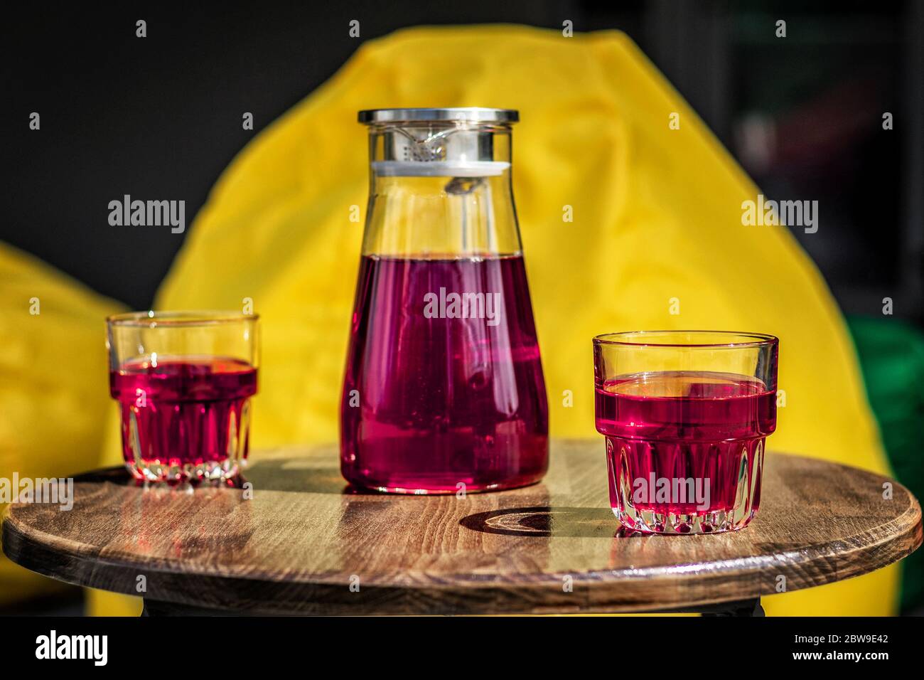 Refreshing drink juice from red berries in glasses and a jug. Summer playground, outdoor cafe, bag chair Stock Photo