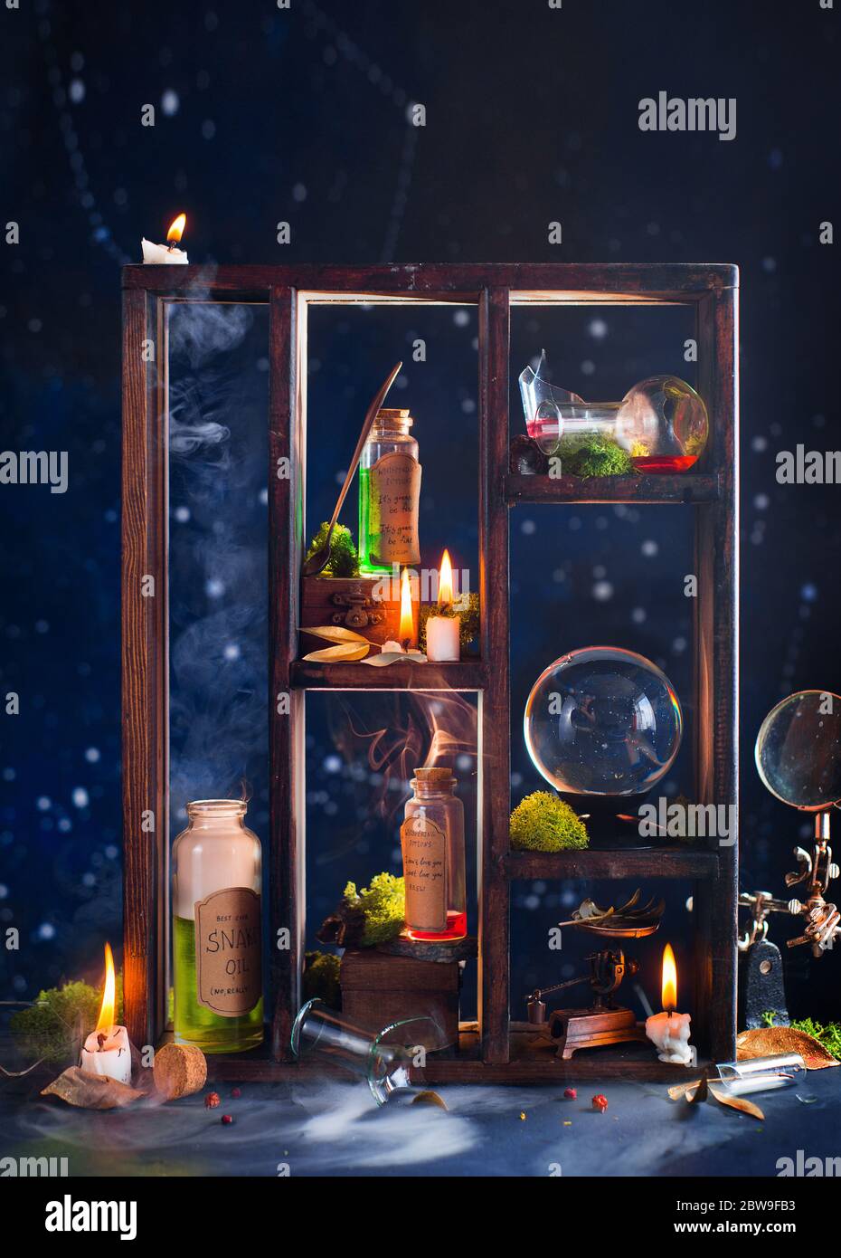Witch workplace with potions, herbs and a crystal ball, magical still life Stock Photo
