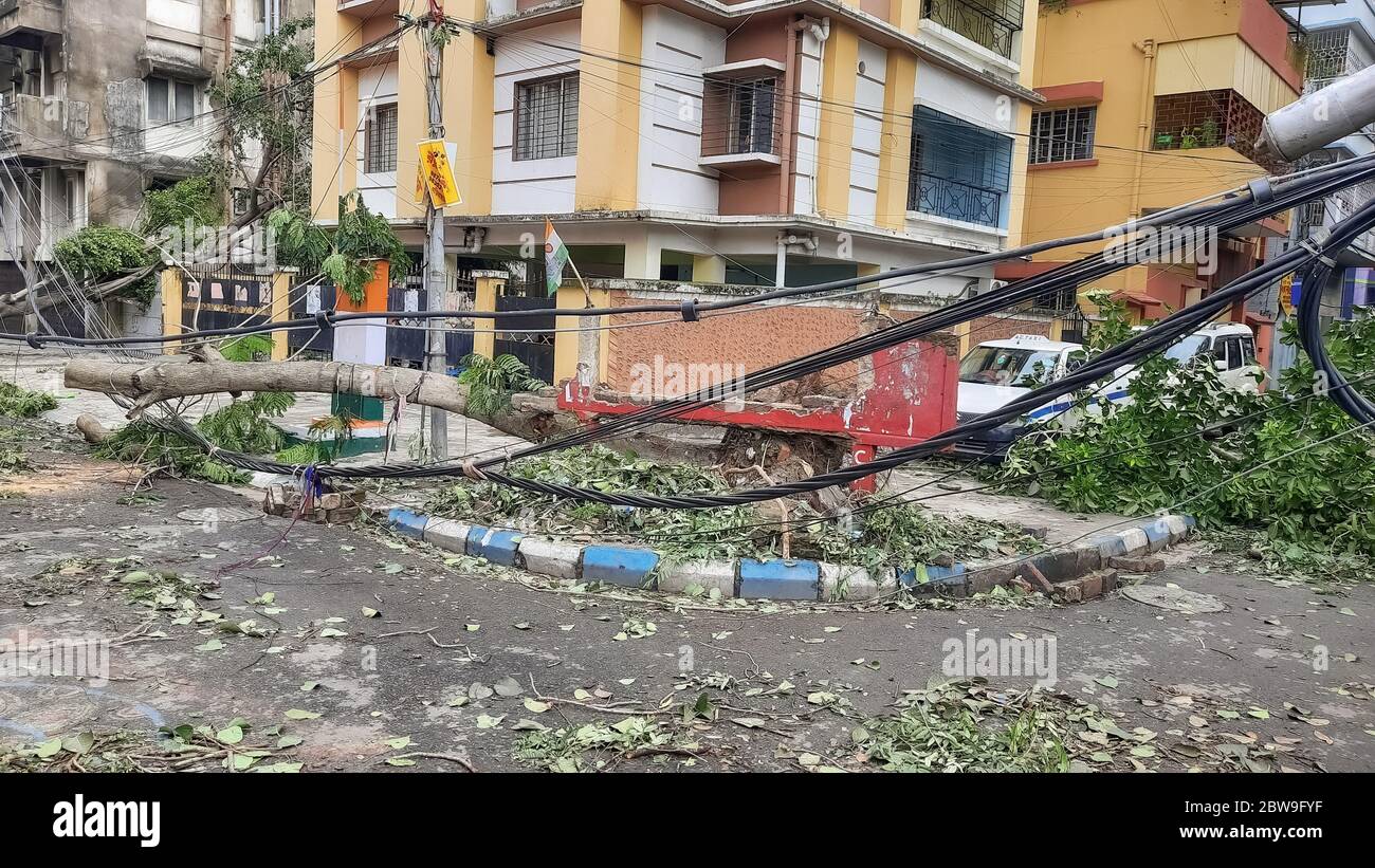 High tension electric wires hanging dangerously from a broken pole on a city road after cyclonic storm 'Amphan' struck landfall at Kolkata, India Stock Photo