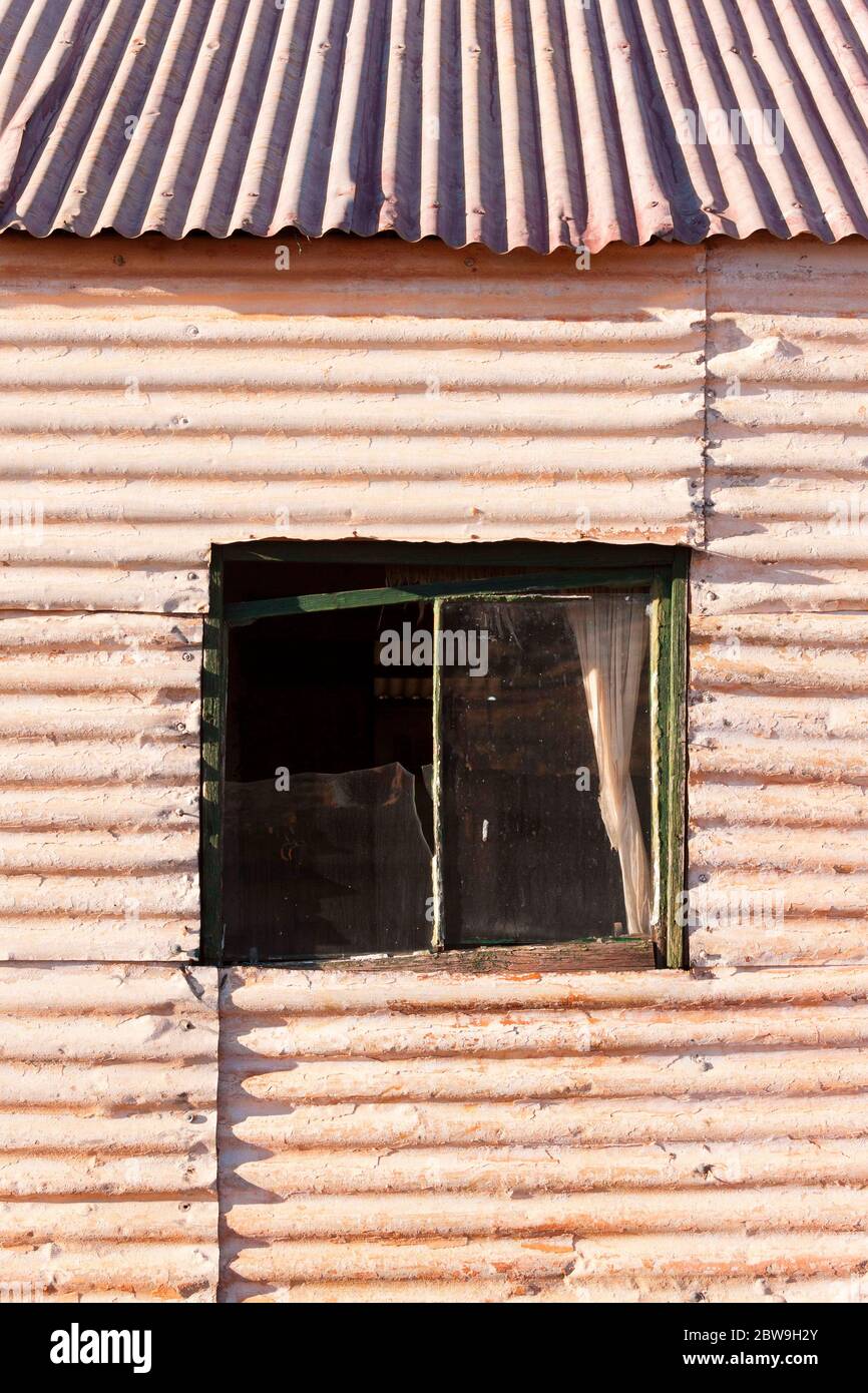 Wood framed window on a Corrugated iron house  of the historical gold mining town Gwalia, Leonora, Western Australia Stock Photo