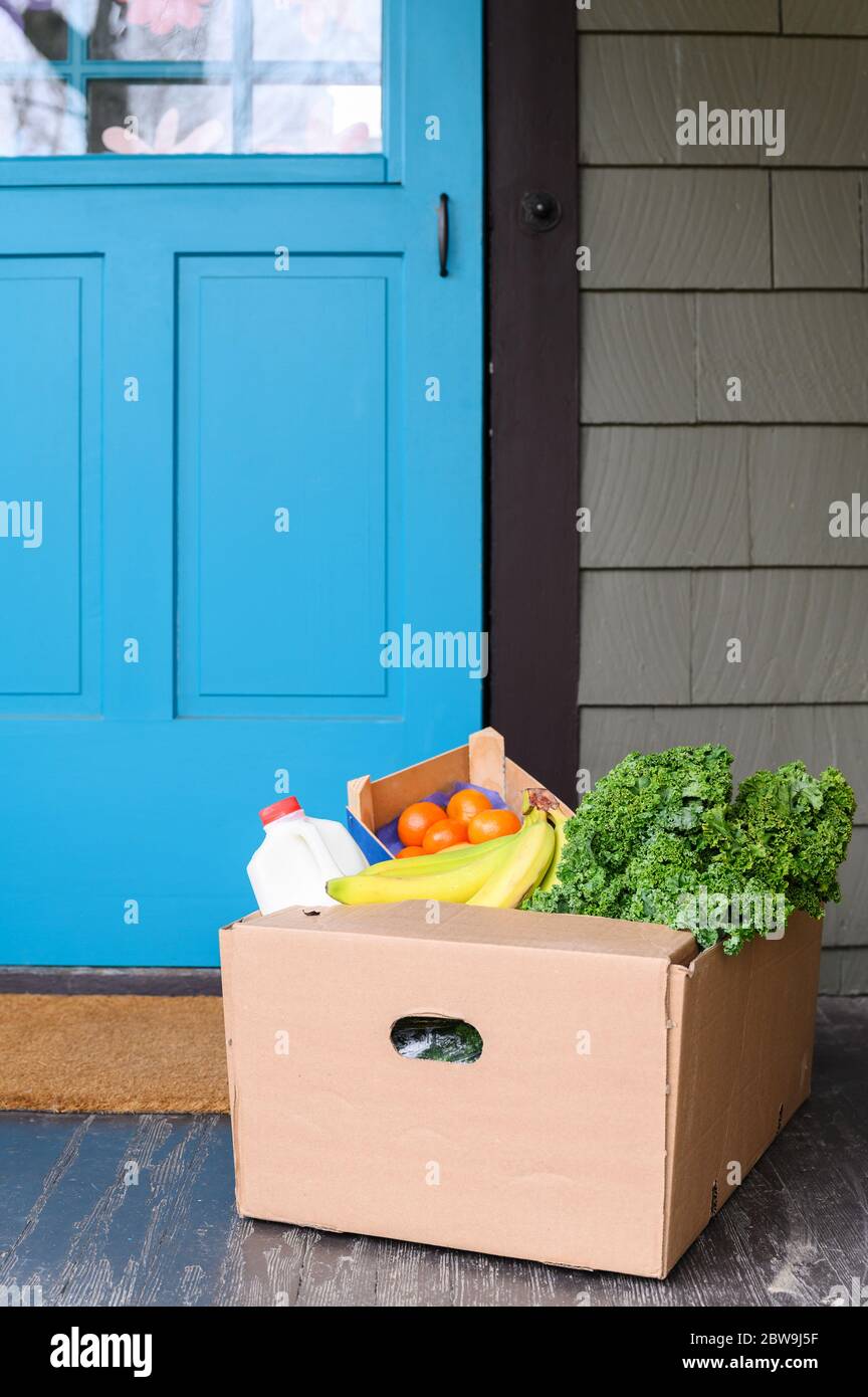 Box of delivered produce on house porch Stock Photo