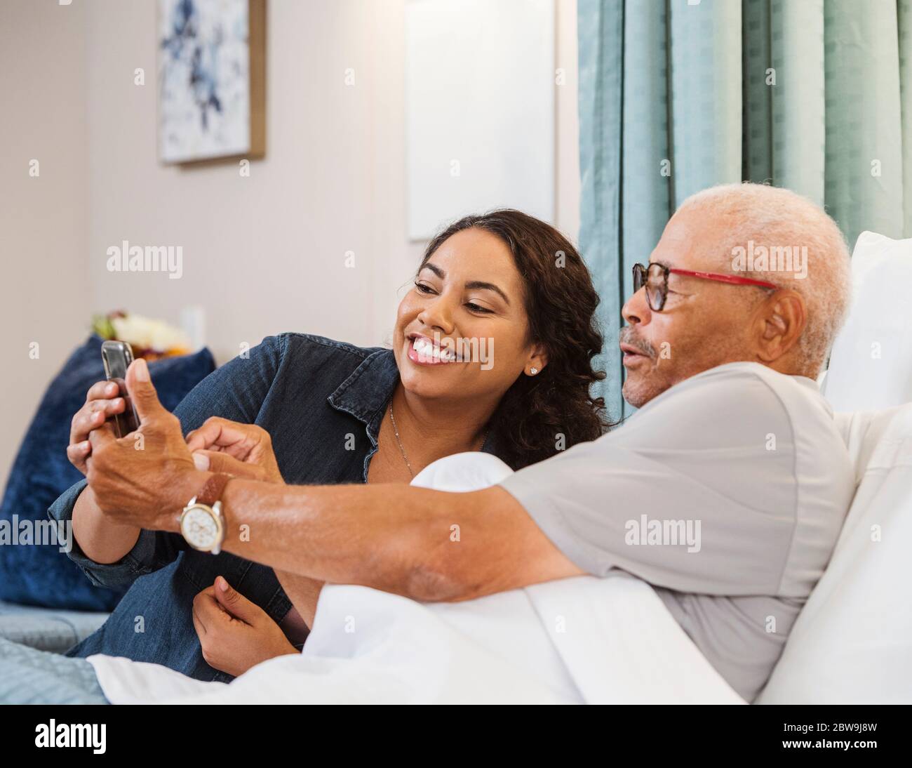 Father and daughter taking selfie in nursing home Stock Photo