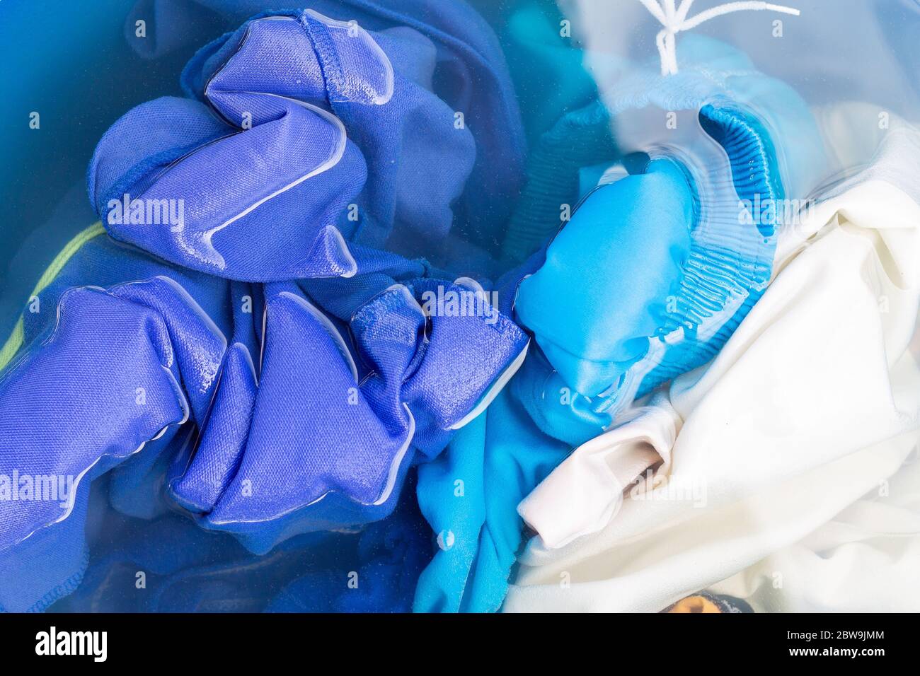 Soak colored clothes before washing them with water. Stock Photo
