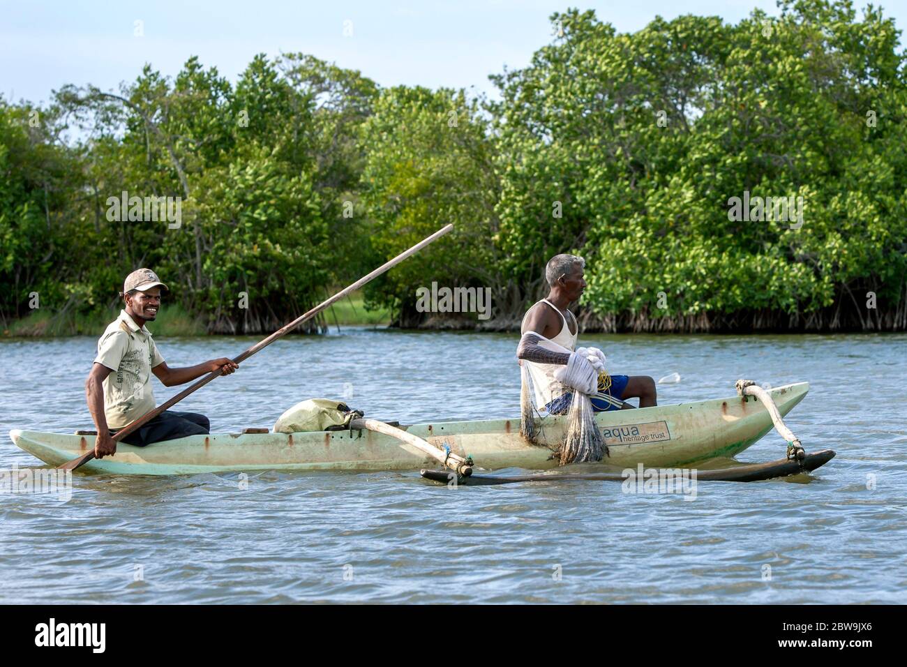 Sri Lankan fisherman paddle their outrigger canoe across Pottuvil