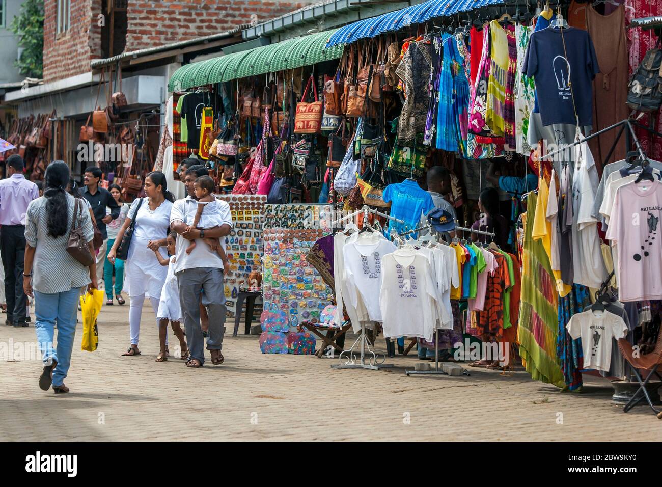 Sri Lankans walk on a deserted street at a wholesale market during