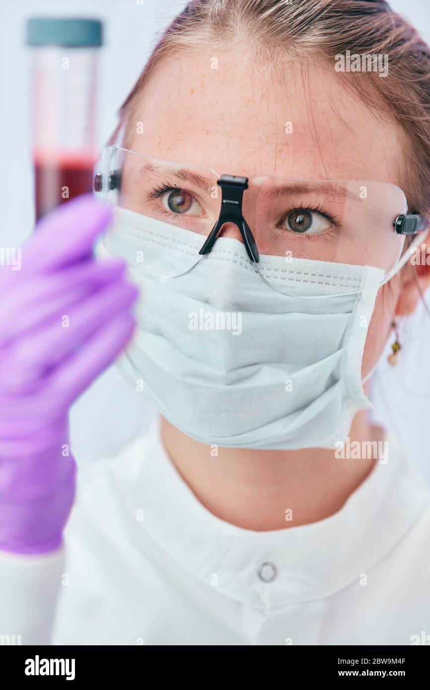 Female technician holding vial Stock Photo