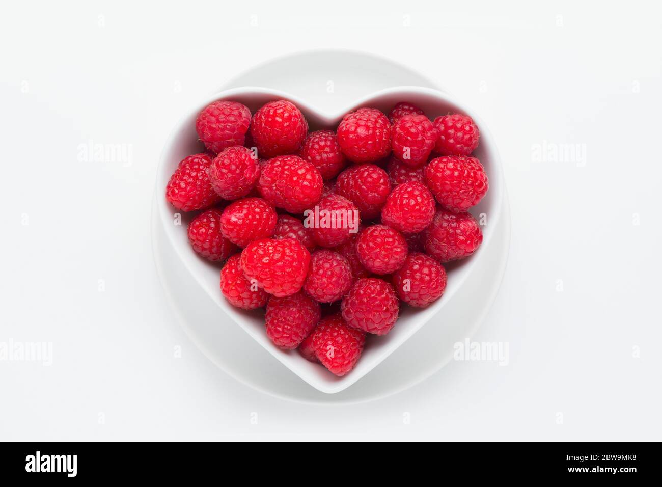 Raspberries in heart-shaped bowl Stock Photo