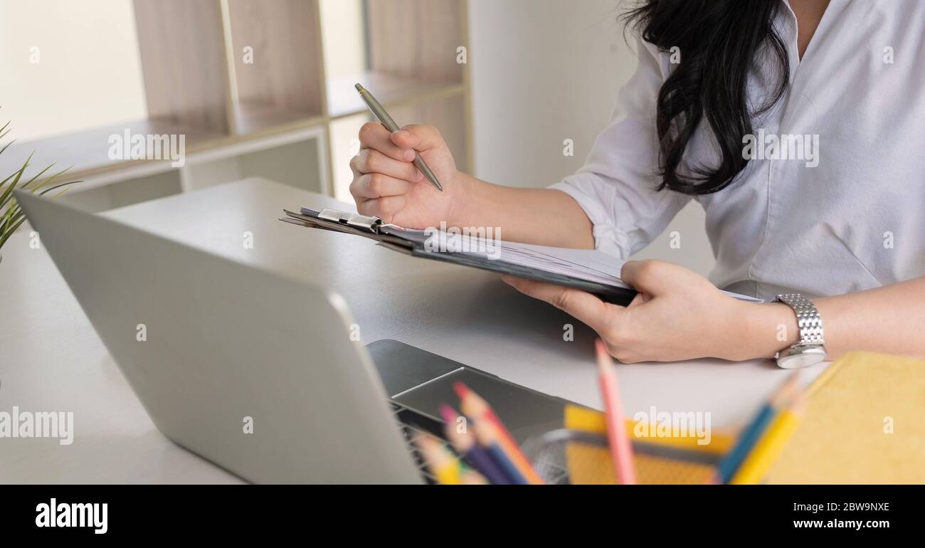 Businesswoman working analysis financial report clipped to pad at workplace closeup Stock Photo