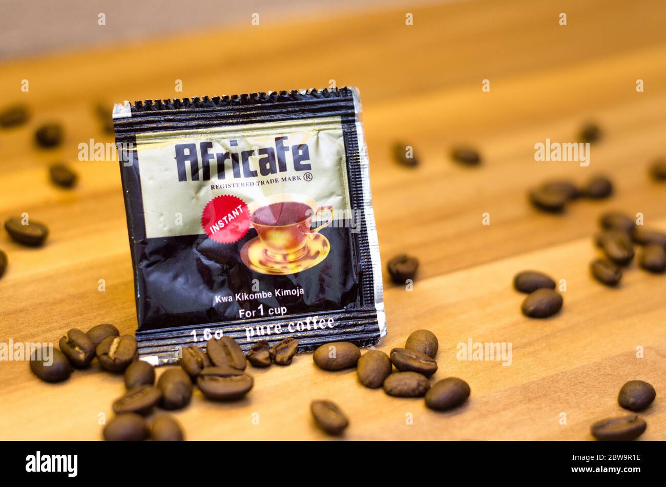 A sachet of instant coffee from Africafe with coffee beans around in a