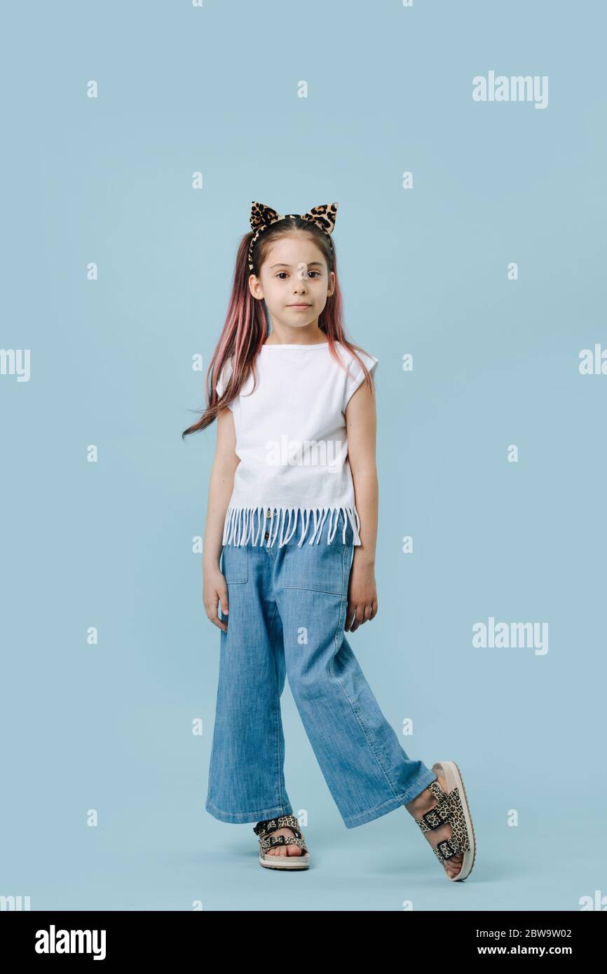 Full length portrait of a cute girl with cat ears headband, posing for a photo. Stock Photo