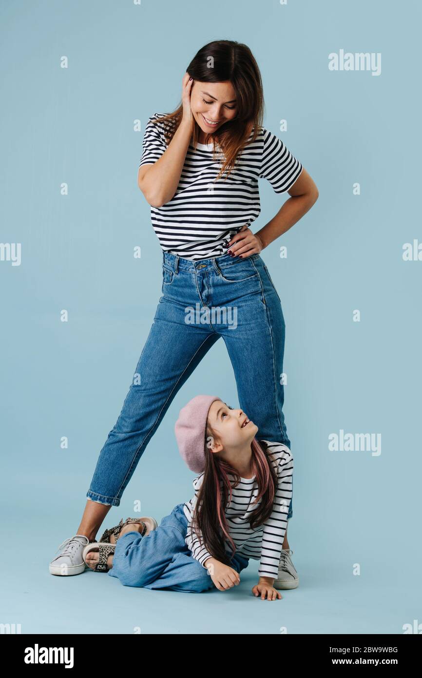 Mom and daughter looking at each other. They are wearing same clothes