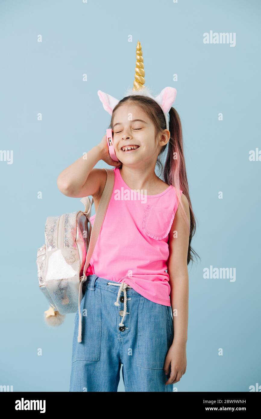 Portrait of a happy little girl speaking on the phone over blue Stock Photo