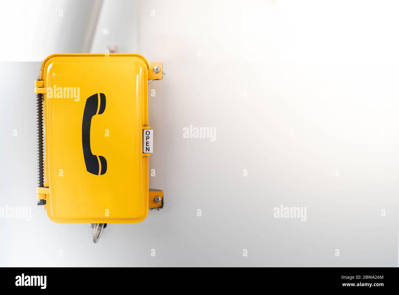 The yellow emergency phone on wall in public area of subway underground