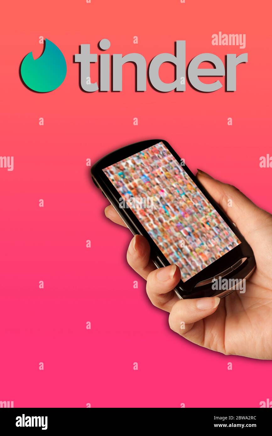 hand holding a smartphone with a Tinder logo as concept for the social media platform for dating Stock Photo