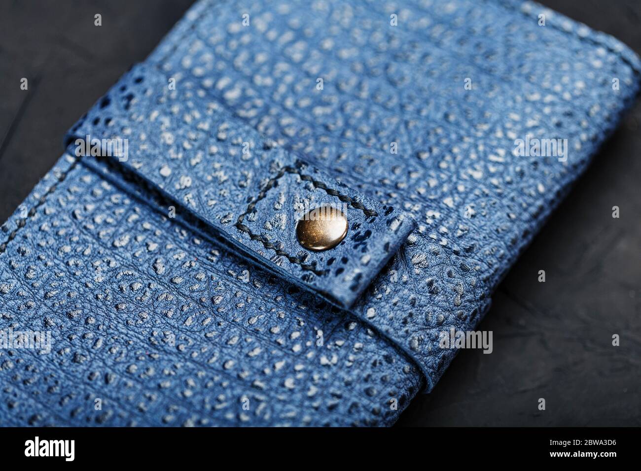 Blue leather wallet on a black textured background. Stock Photo