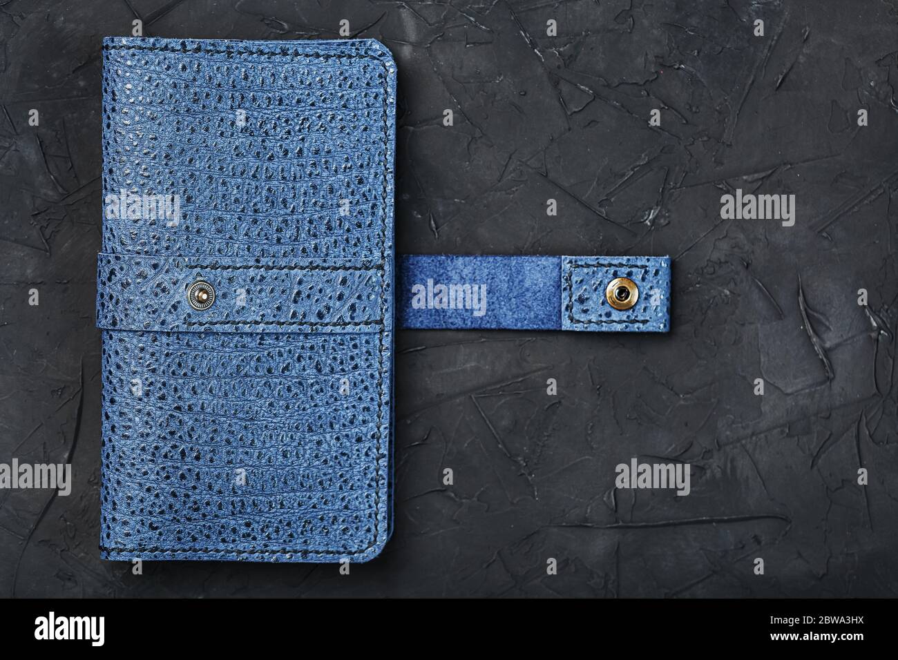 Blue leather wallet on a black textured background. Stock Photo