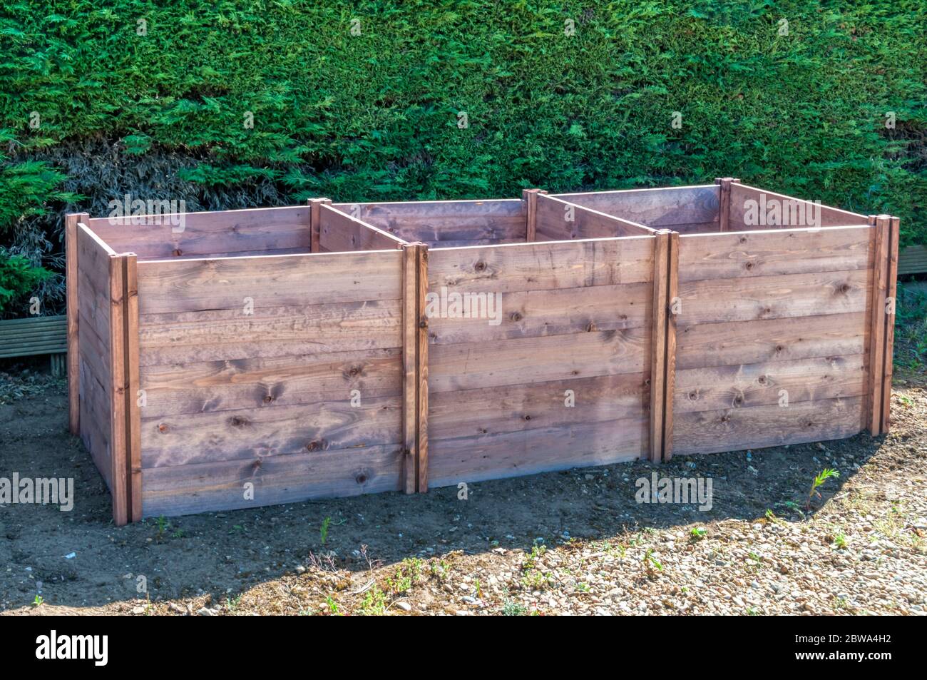 A traditional slot down wooden triple compost bin. Stock Photo