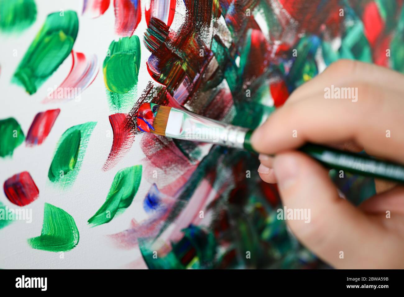 https://c8.alamy.com/comp/2BWA59B/hands-holding-brush-with-multi-colored-paint-2BWA59B.jpg