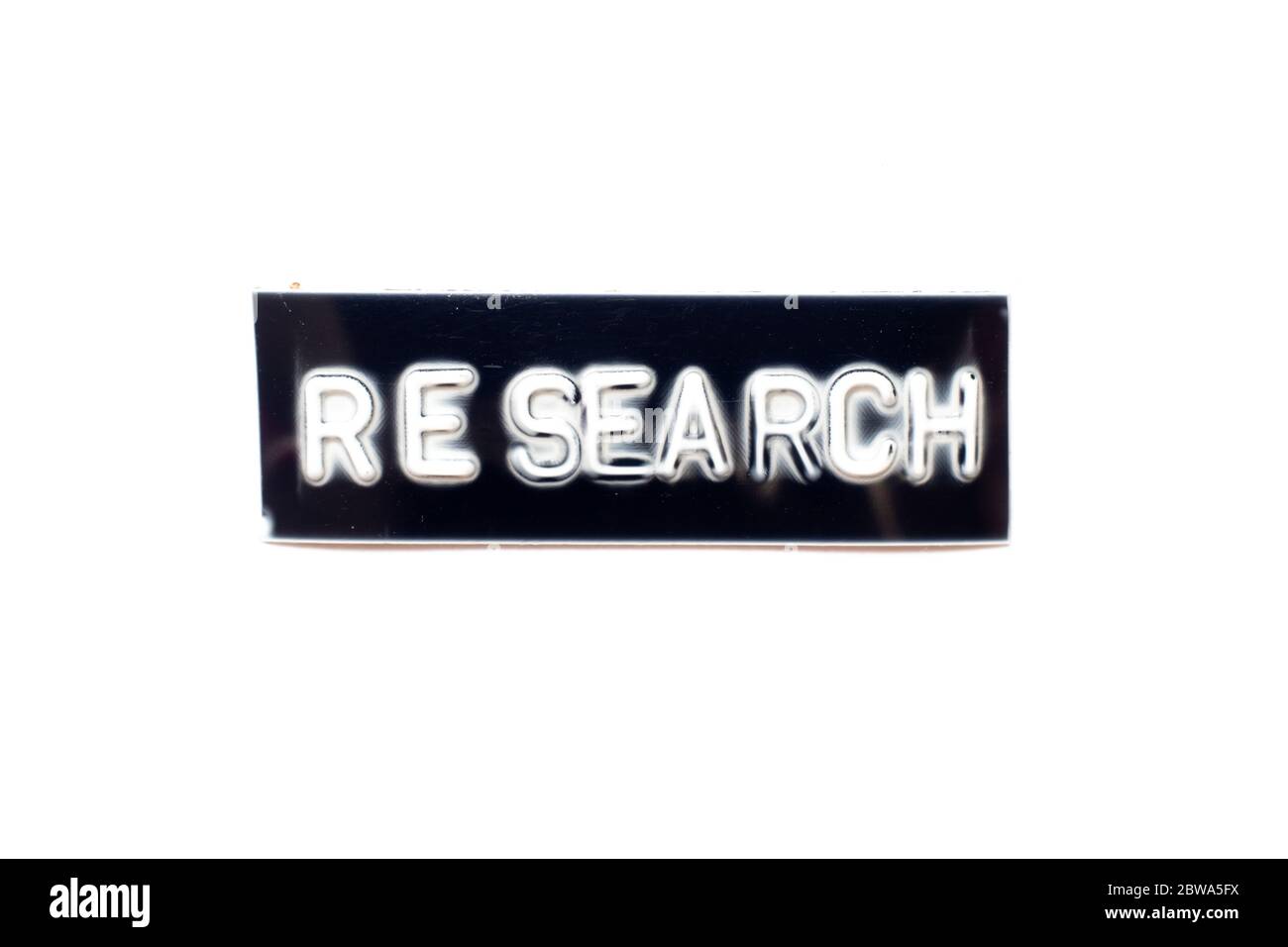 Embossed letter in word research in black banner on white background