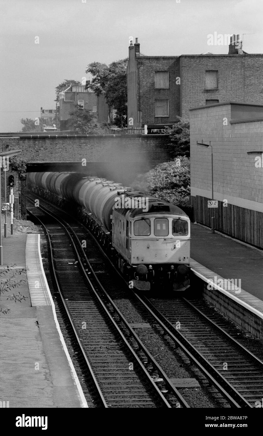 Class 33 diesel locomotive No. 33212 at Caledonian Road and Barnsbury station with a westbound oil train, London, UK. 8th September 1986. Stock Photo