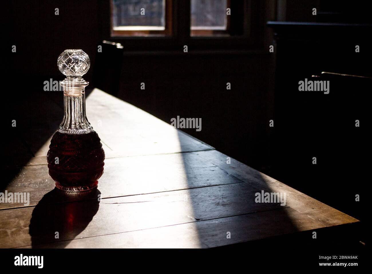dark red liquor in beautiful decanter on wooden table Stock Photo Alamy