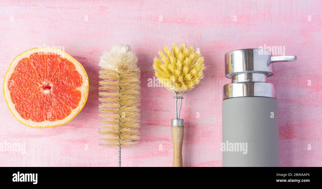 Bottle and dish brush, liquid soap. Grapefruit near it. Zero waste and natural ingredients home cleaning concept.Top view, layout. Stock Photo