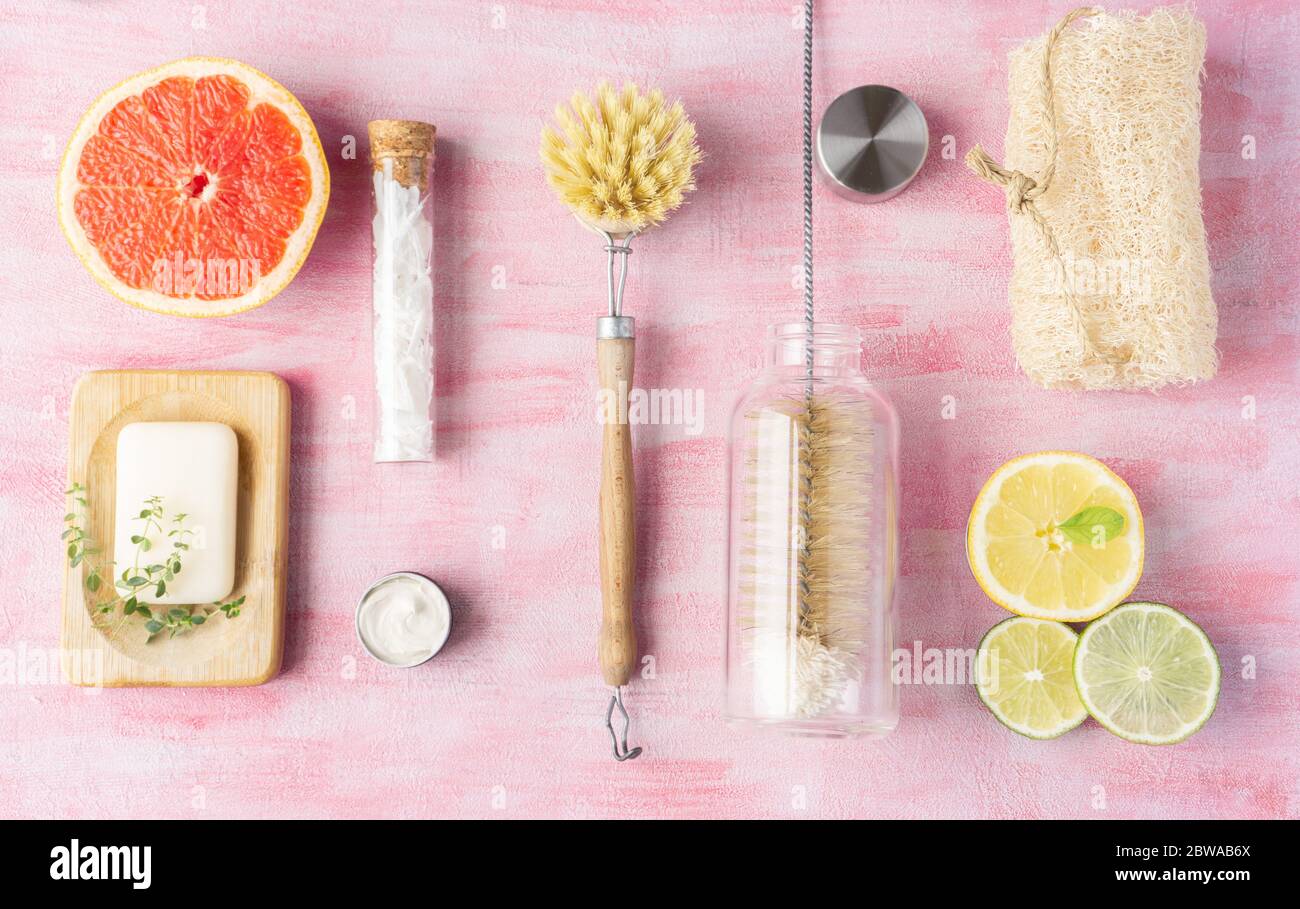 Bottle and dish brush, soap, cleaning powder, loofah. Some citrus and herbs near. Zero waste and natural ingredients home cleaning concept. Top view, layout. Stock Photo