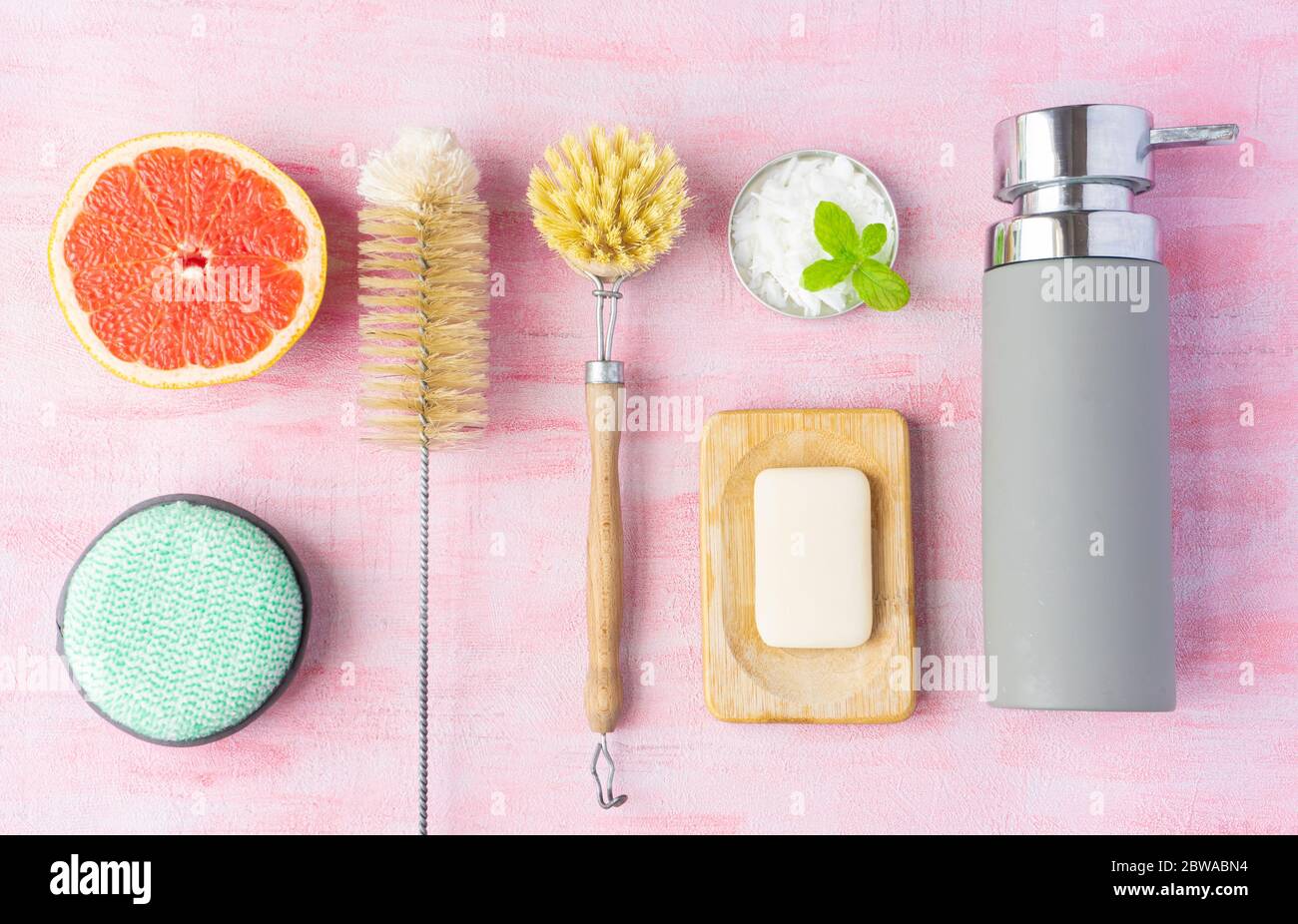 Bottle and dish brush, soap, cleaning powder, cotton washcloth for dishes. Grapefruit and mint near it. Zero waste and natural ingredients home cleaning concept. Top view, layout.ish brush, soap, cleaning powder, cotton washcloth for dishes. Grapefruit and mint near it. Zero waste and natural ingredients home cleaning concept. Top view, layout. High quality photo Stock Photo