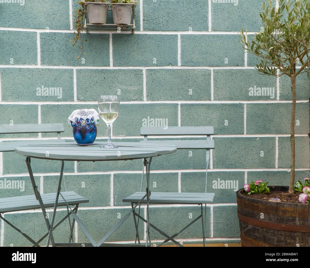 Patio table and chairs with wine glass and ceramic jug. April 2020 Stock Photo Alamy