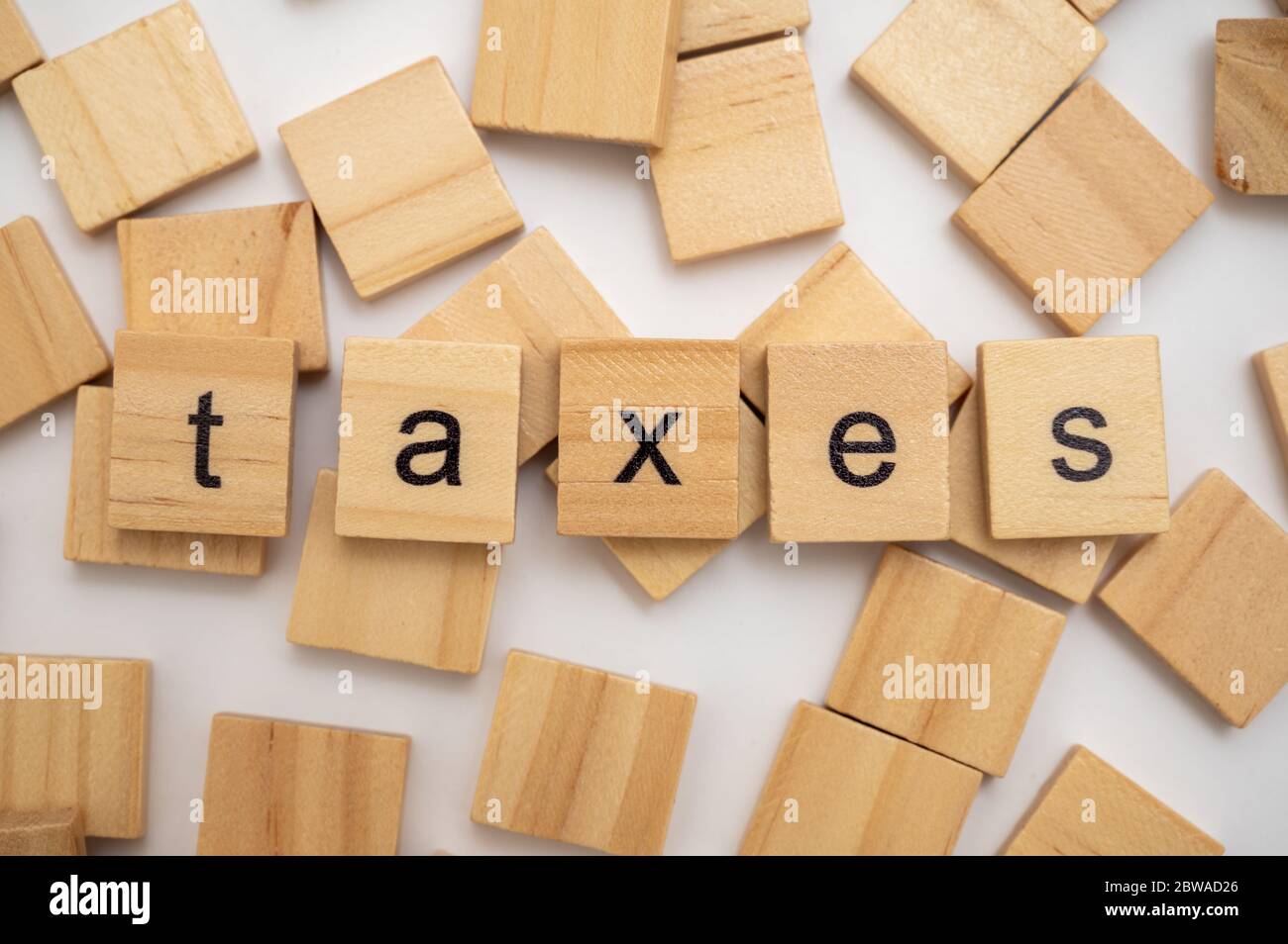 Wooden letter tiles spelling the word TAXES Stock Photo