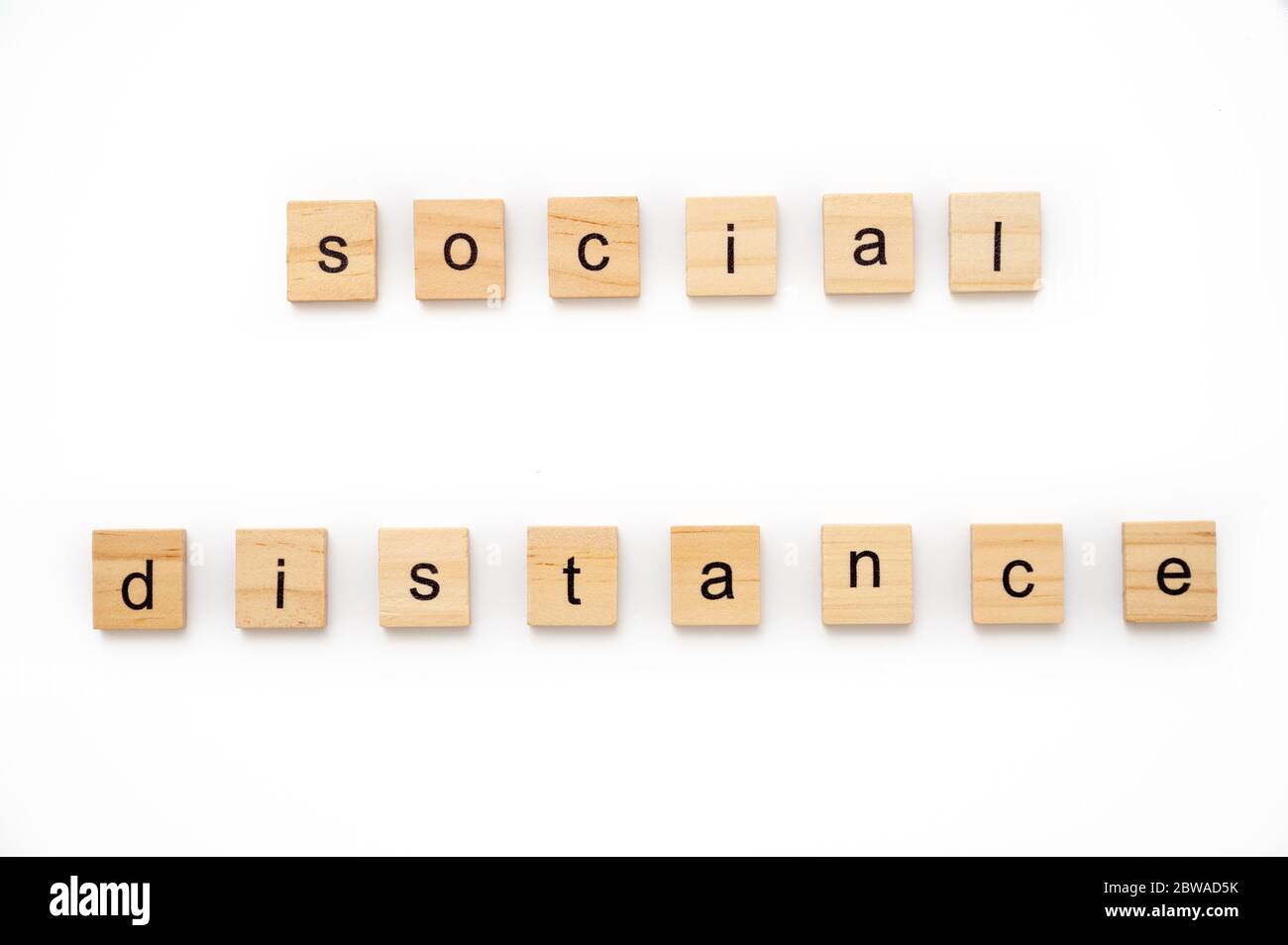 Wooden letter tiles spelling the wordS SOCIAL DISTANCING Stock Photo