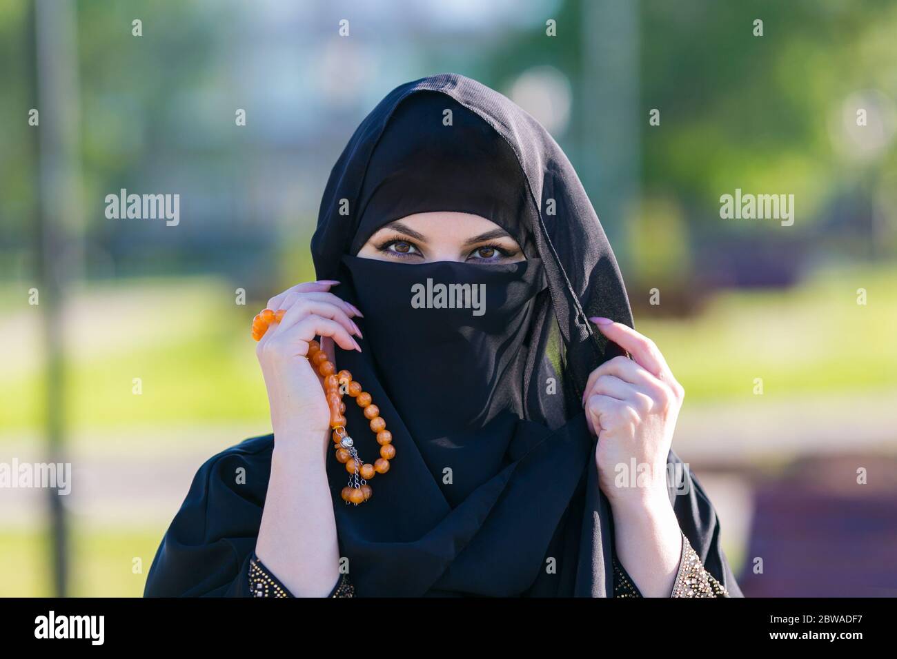 Muslim woman stands with rosary Islamic scores. Stock Photo