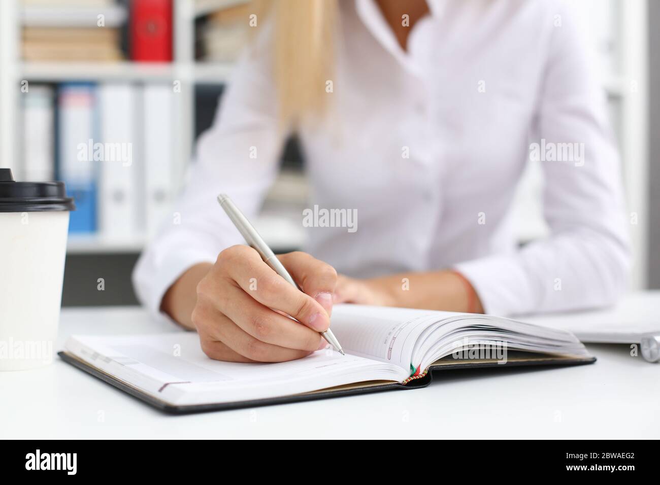 Female hand holding silver pen ready to make note Stock Photo - Alamy