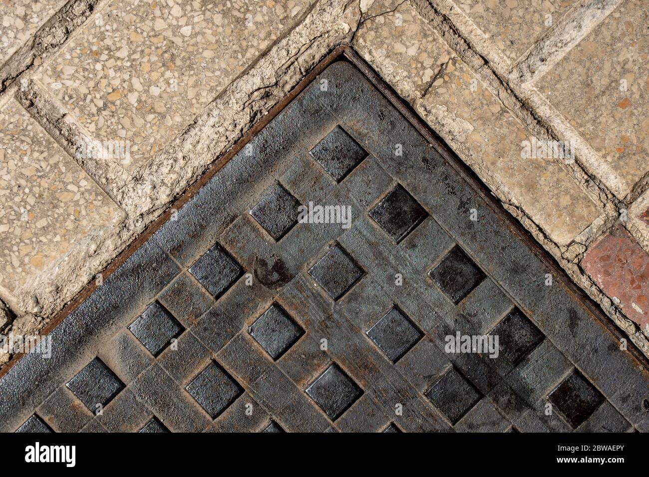 Square manhole cover on the sidewalk. Closeup texture. Top view Stock