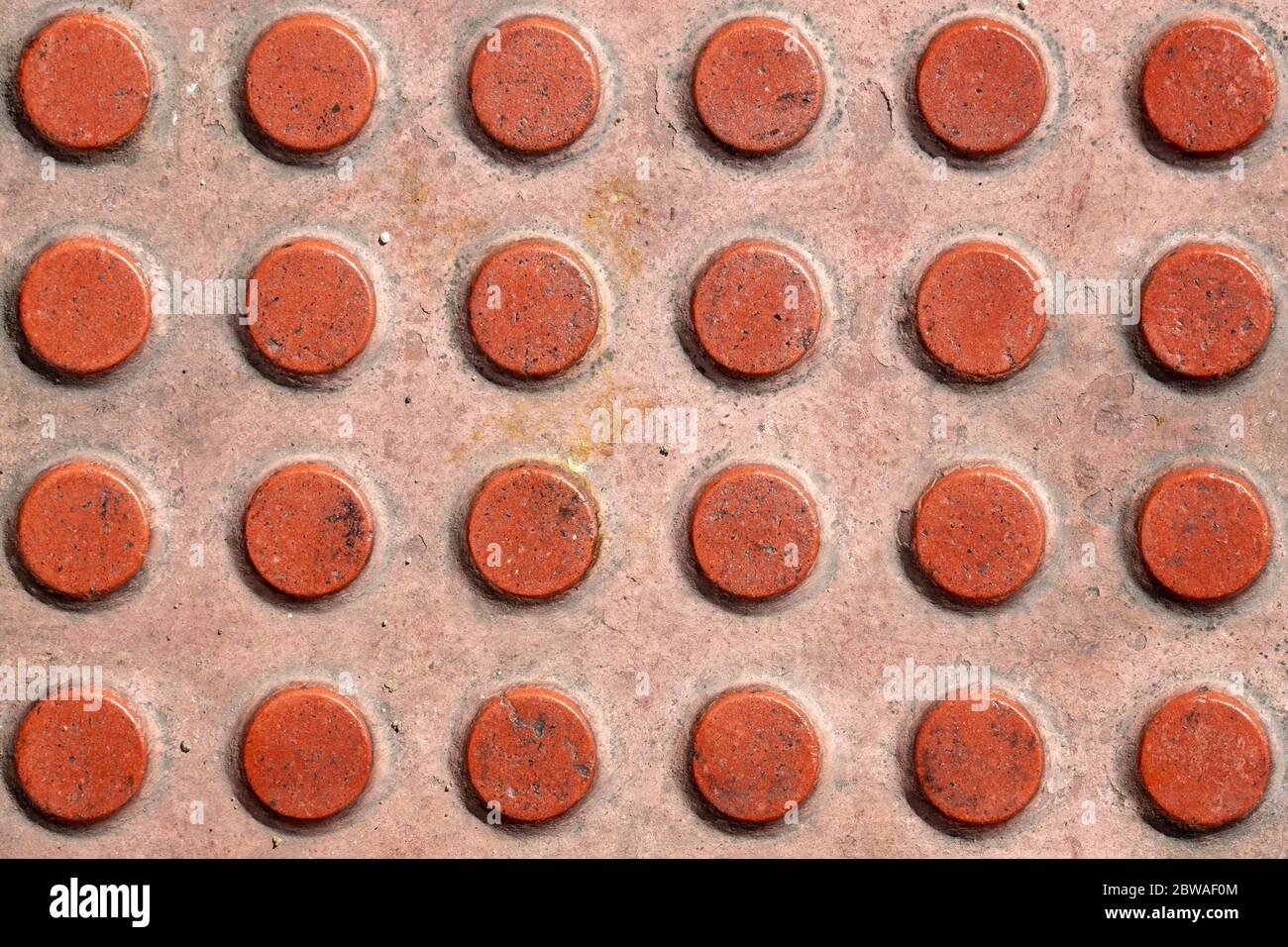 Tactile paving texture. Truncated domes top view. Detectable warnings. Close-up of walking surface indicators. Stock Photo