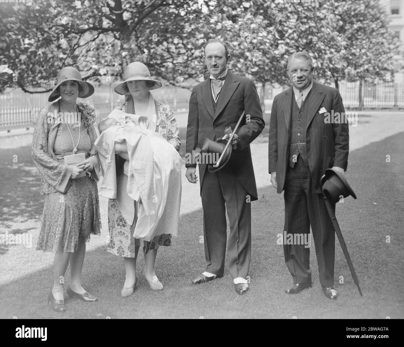 Christening of infant son of Capt and Mrs Cuthbert Reaveley at Holy Trinity church , Marylebone . Mrs Reaveley , Marchioness Townshend of Raynham ( Godmother ) , Capt Reaveley and Air Vice Marshal Sir Sir Vyell Vyvyan , KCB DSO , ( Godfather ) . 18 June 1929 Stock Photo