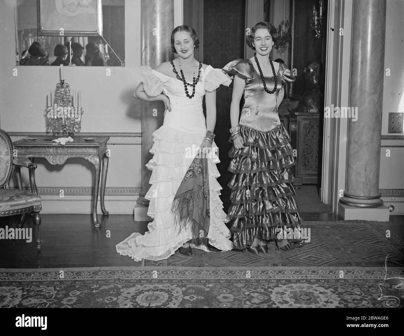 At rehearsals for the ' Spanish Night ' Ball , which is to be held at Grosvenor House , Lady Pamela Smith , left , in her lovely all white , Andalusian dress and the Honourable Sheila Berry in her red Andalusian dress . Stock Photo