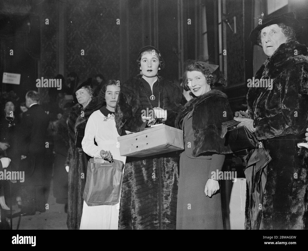 Pictured at the Country Produce Market held at Grosvenor Hall , Buckingham Palace Road , on behalf ot the ' Friends of the Poor ' , is the Duchess of Richmond and Gordon ( second from right ) making a purchase at a stall . 25 November 1936 Stock Photo