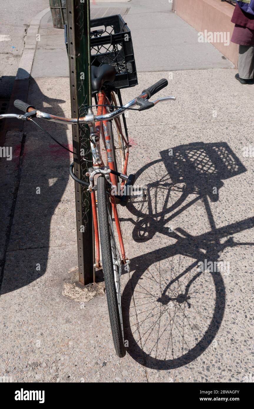 Bicycle locked to pole on sidewalk, Brooklyn, New York, USA Stock Photo