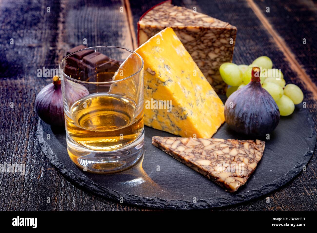 Tasting of Irish blended whiskey and cheeses from Ireland and UK, dark background Stock Photo