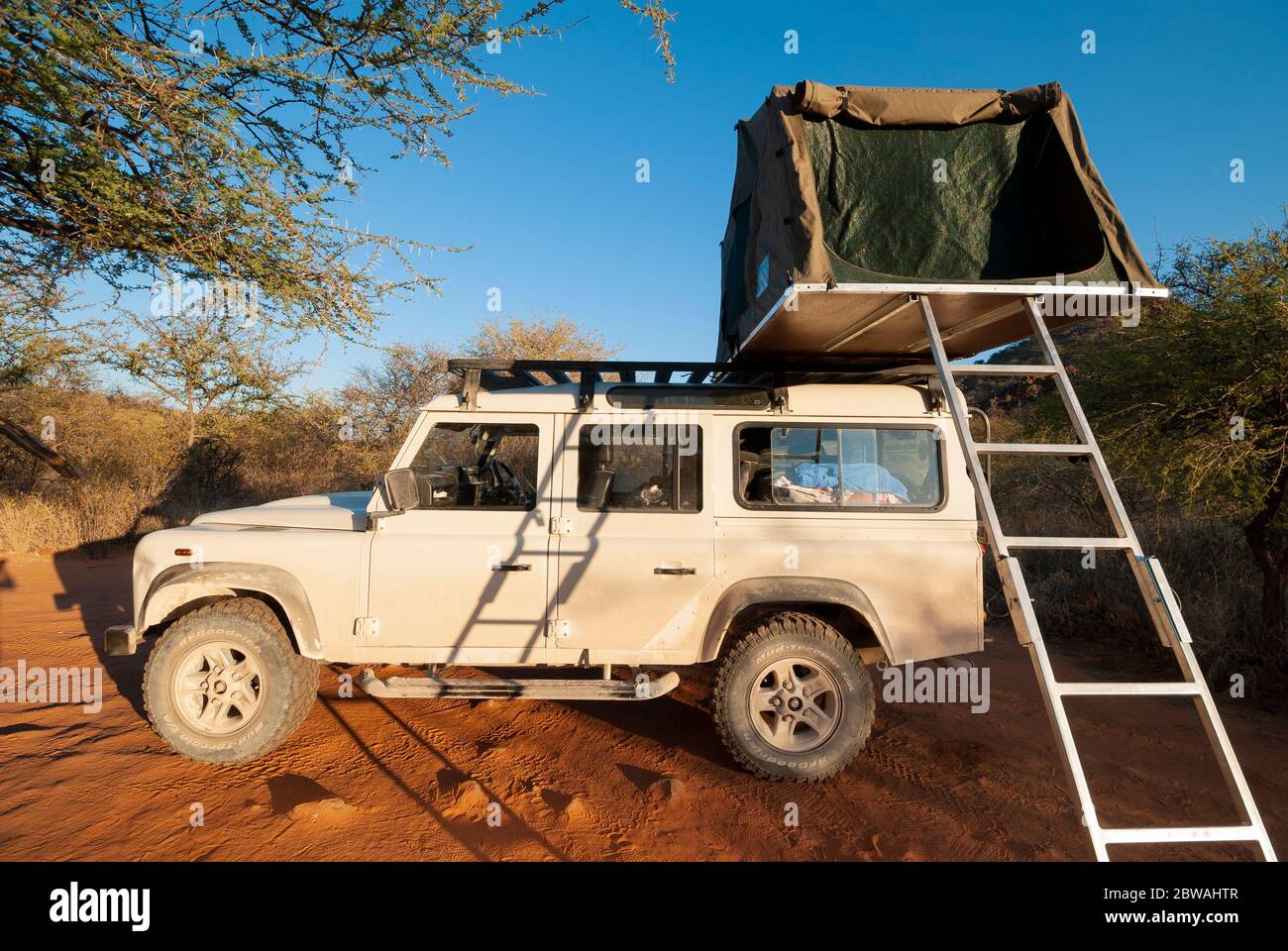 A 4WD car (landrover) with rooftop tent on Safari in Etosha National Park, Namibia, Southern Africa. Stock Photo