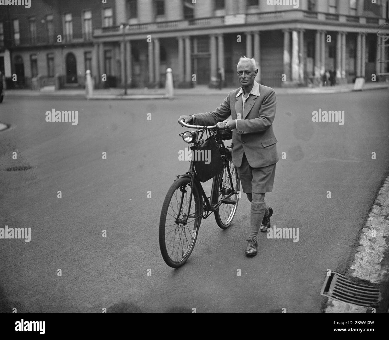 Dr Alfred C Jordan , acting Honourable Secretary of the ' Mens Dress Reform Party ' , arriving at his consulting rooms in the West End of London with his bicycle in ' shorts ' and an open - necked shirt . 14 June 1929 Stock Photo