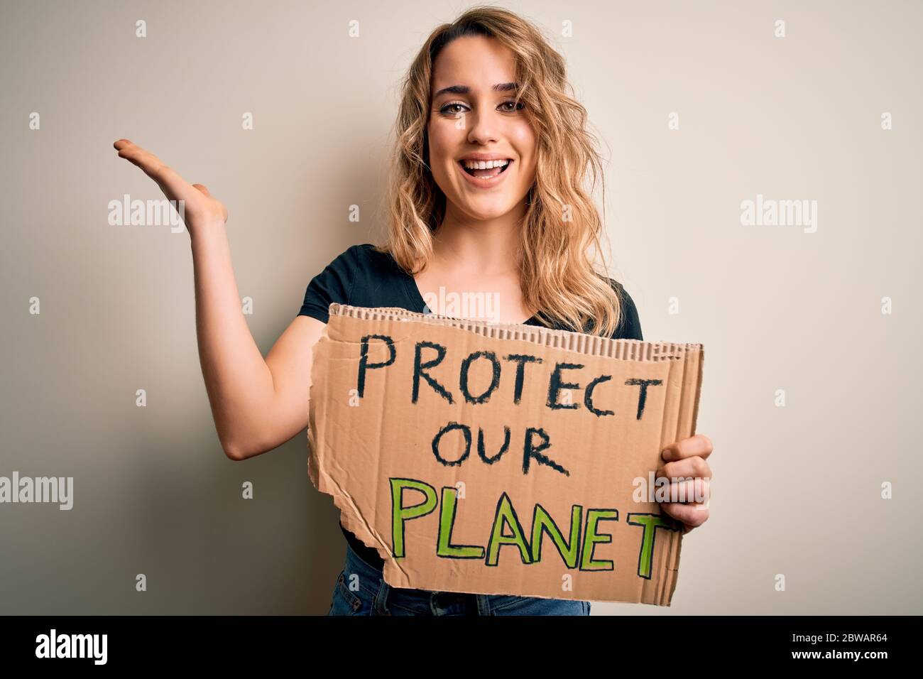 Young activist woman asking for environment holding banner with protect ...